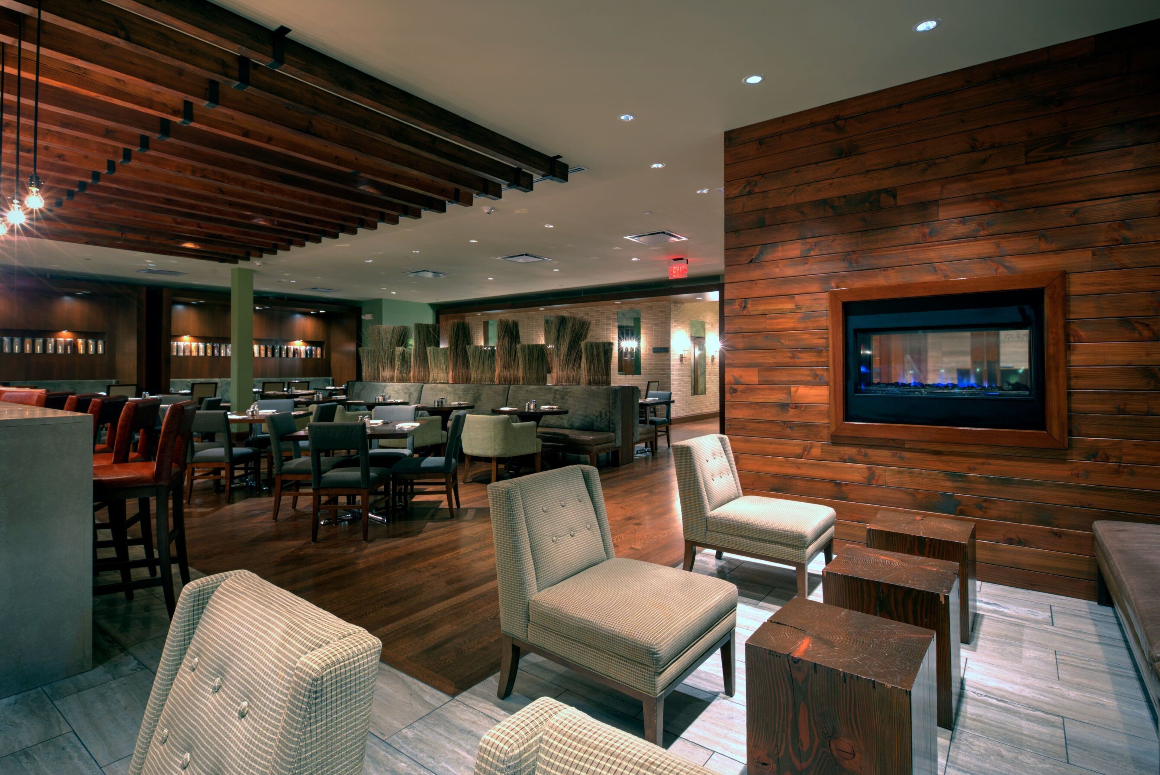 A modern interior with wooden panel walls, a bar area, and seating arrangements.