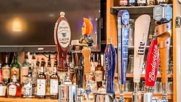 A bar with various beer taps including brands like Guinness, Budweiser, and Samuel Adams.