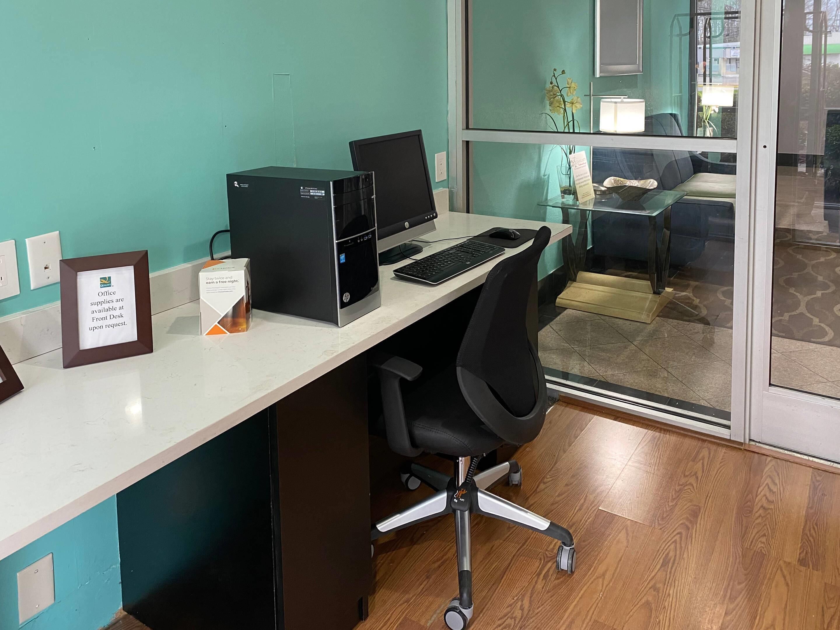 Un escritorio moderno con una computadora de escritorio, una laptop y una silla.