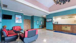 Eine Hotelhalle mit türkisblauen Wänden, einer Rezeption und Sitzbereichen.
