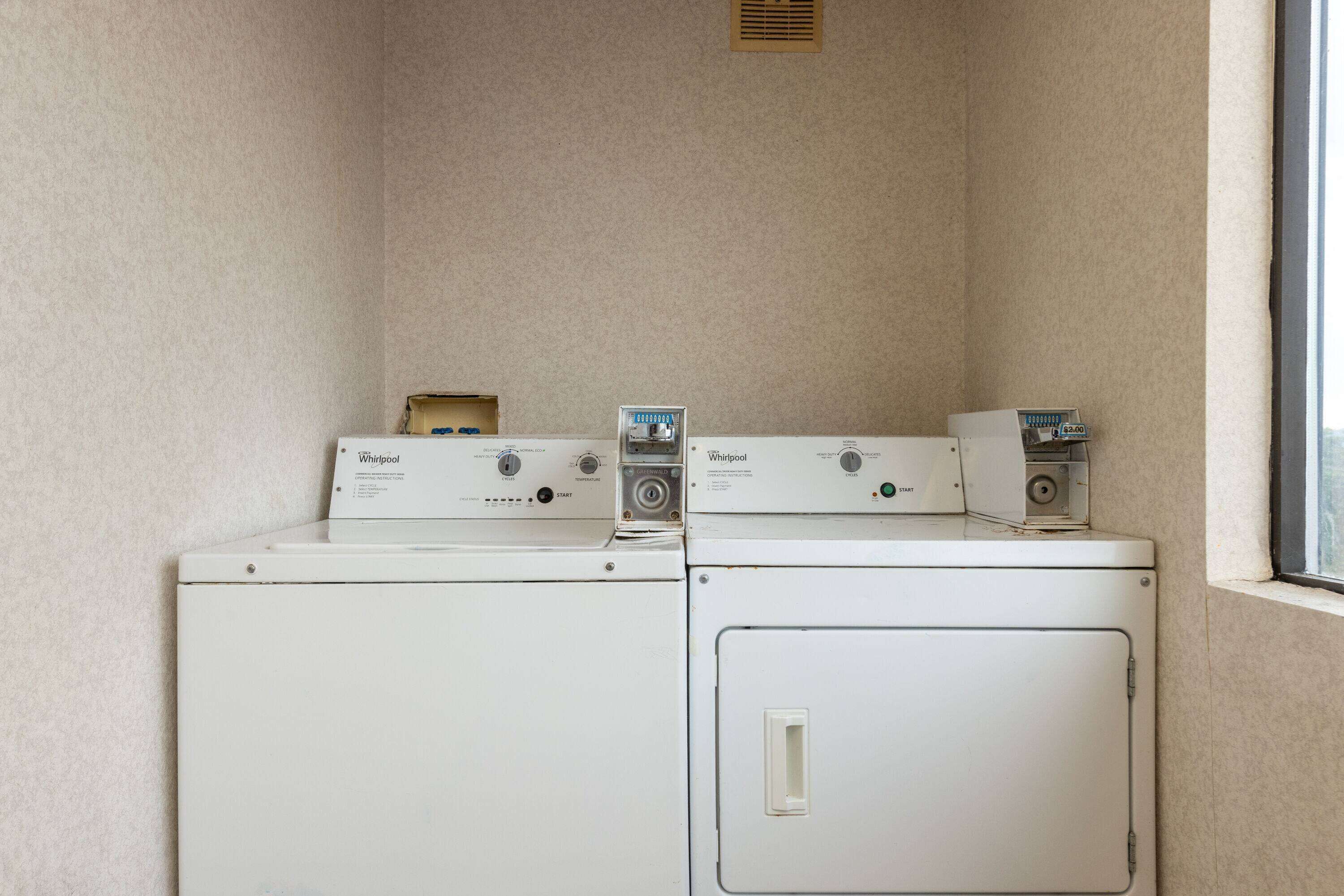 A laundry room with two stacked washers and a dryer.