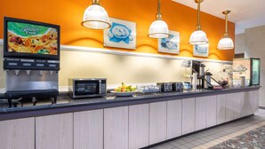 Ein Hotel-Empfangsbereich mit Obstauslage, einer Kaffeemaschine und einer Mikrowelle.