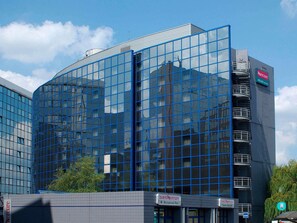A modern hotel with a glass facade, a restaurant-bar, and an entrance lobby.
