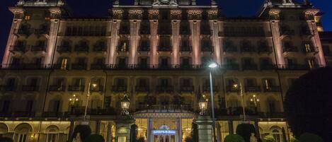A grand hotel with a central entrance, large columns, and a clock tower.
