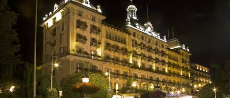 A large, multi-story hotel with a classic European architectural style, featuring balconies and ornate detailing.