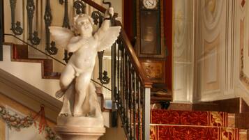 Eine prächtige Treppe mit einer Engelsstatue, einer Uhr und aufwendiger Geländer.