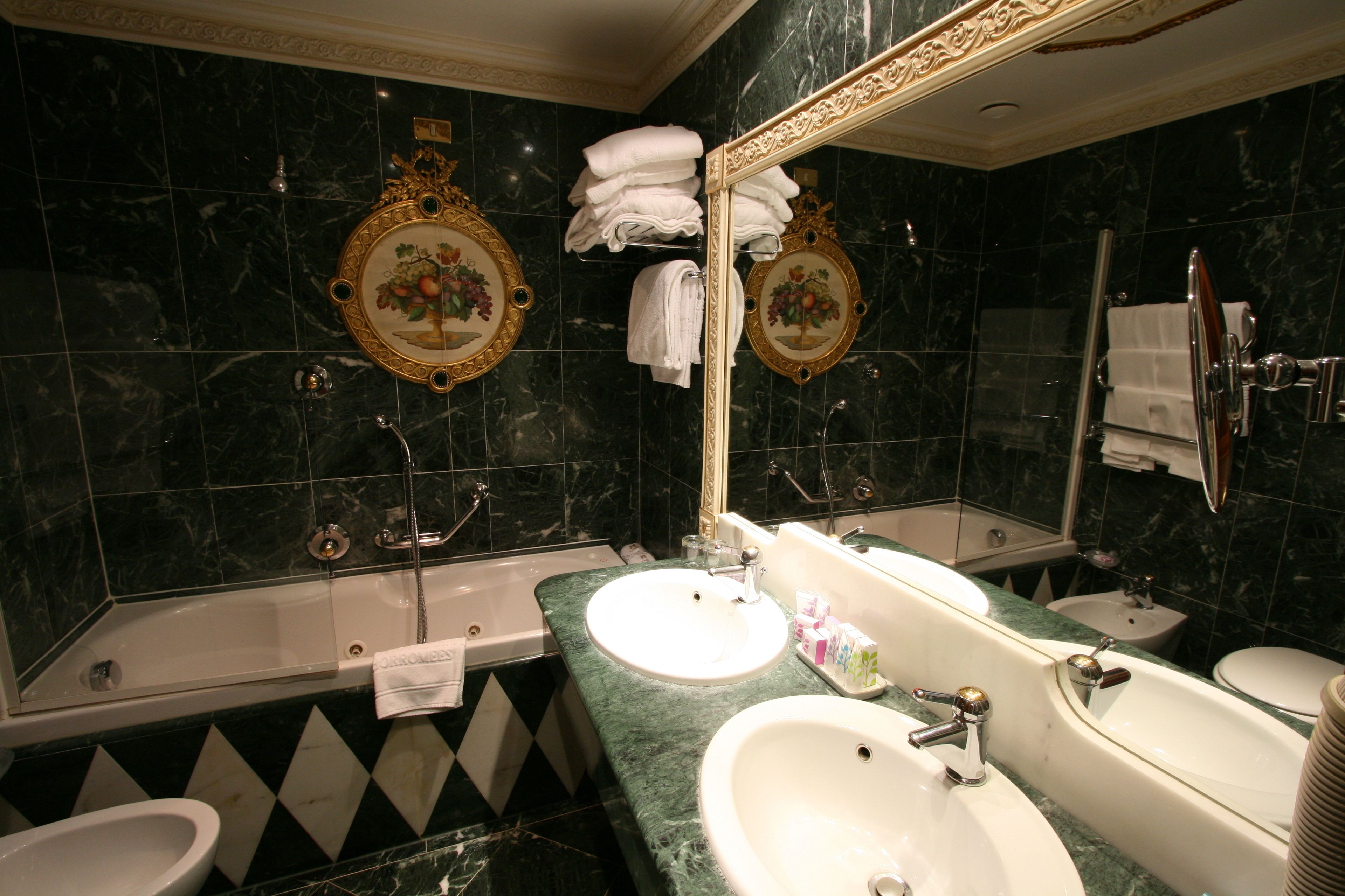 Un baño con dos lavamanos, una bañera, un inodoro y una ducha.