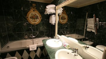 Un baño con dos lavamanos, una bañera, un inodoro y una ducha.
