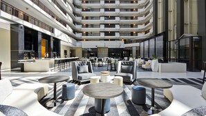 A multi-level atrium with seating areas, a bar, and a view of the upper floors. - Embassy Suites Hotel Charlotte (Charlotte)