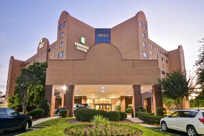 A hotel with a modern design, featuring a prominent entrance and a landscaped garden area. - Embassy Suites Hotel Charlotte (Charlotte)