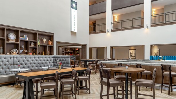 A hotel lobby with a seating area, a bar, and a staircase. - DoubleTree by Hilton Lubbock University Area (Lubbock)