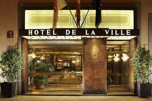 L'ingresso dell'Hotel de la Ville, con una facciata imponente, ampie vetrate e un cartello ben visibile.