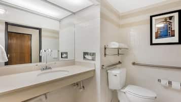 Een moderne badkamer met een wit wastafelmeubel, spiegel en toilet.