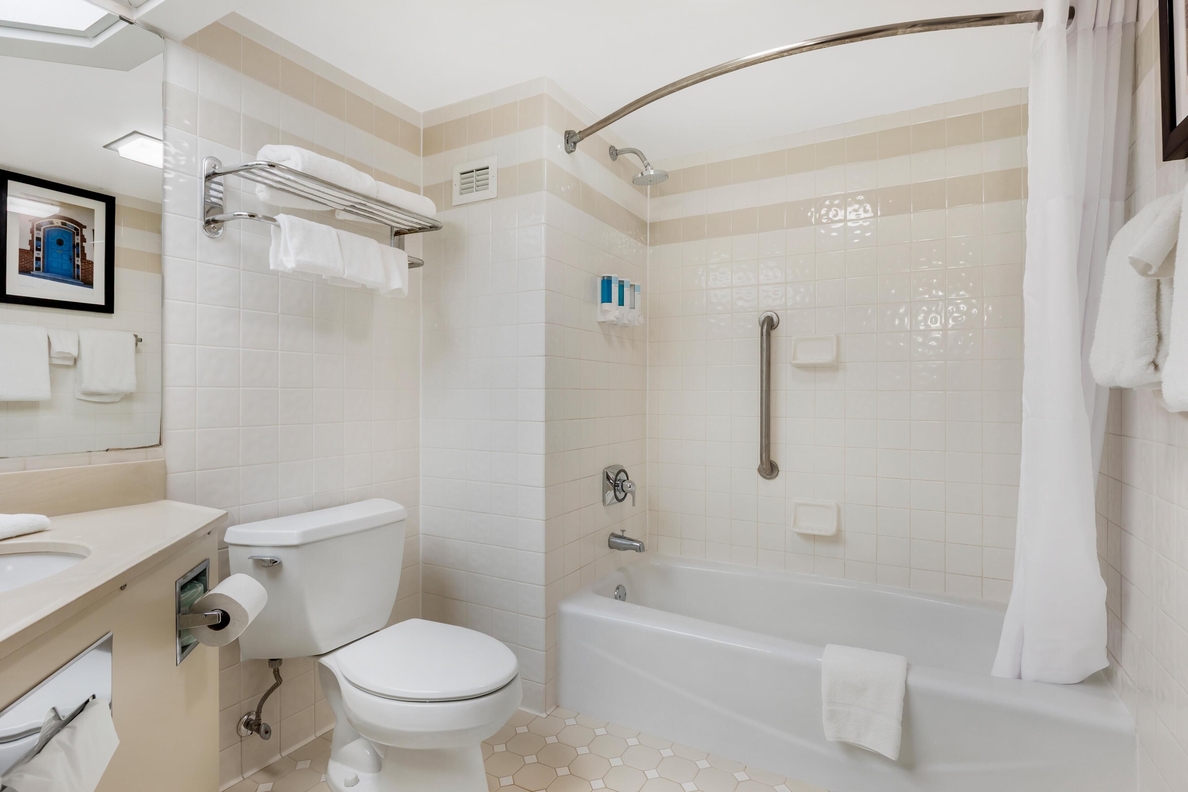 Une salle de bain moderne équipée de toilettes, d’un lavabo et d’une baignoire.