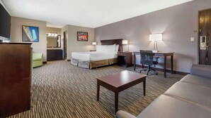 A hotel room with a bed, desk, chair, and a small table. - Best Western McCarran Inn (Las Vegas)