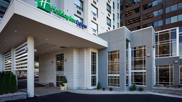 A Holiday Inn Express hotel with a modern facade, large windows, and a well-maintained entrance area.