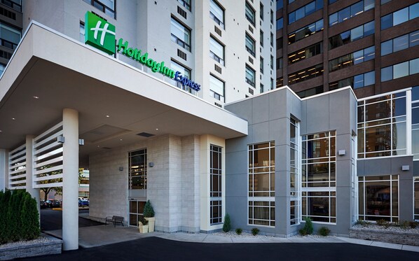 A Holiday Inn Express hotel with a modern facade, large windows, and a well-maintained entrance area.