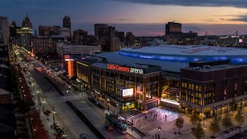 Un paisaje urbano donde se destaca el Little Caesars Arena, con un letrero grande e iluminado.