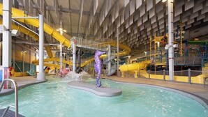 An indoor water park with a central pool, slides, and a seahorse ride. - Holiday Inn Express Windsor Waterfront by IHG (Windsor)