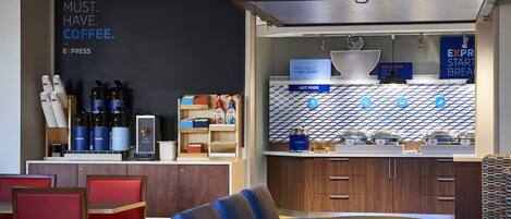 A modern cafe with seating, coffee machines, and a menu board.
