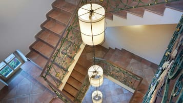 Eine Treppe mit aufwendiger Metallgeländerung und einer hängenden Leuchte.