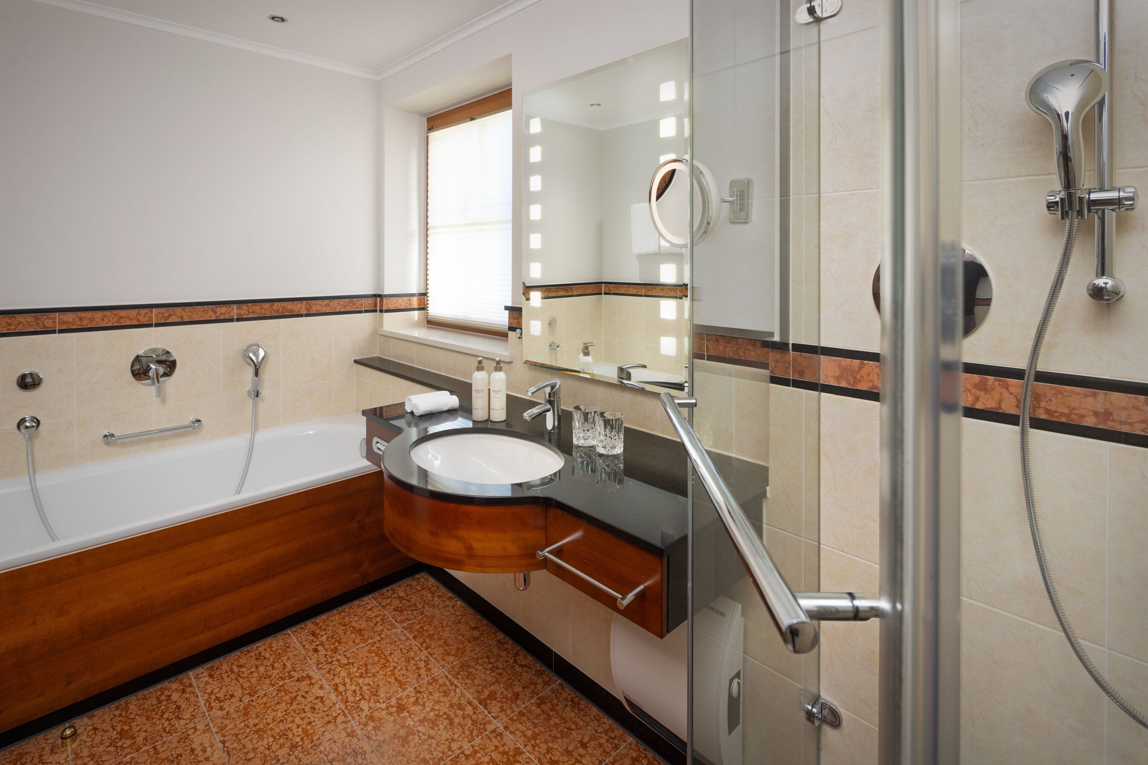 Ein modernes Badezimmer mit Badewanne, Waschtisch und Dusche.