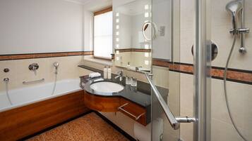 Ein modernes Badezimmer mit Badewanne, Waschtisch und Dusche.