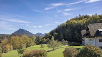 A mountain landscape with a building featuring a sloped roof and multiple windows.