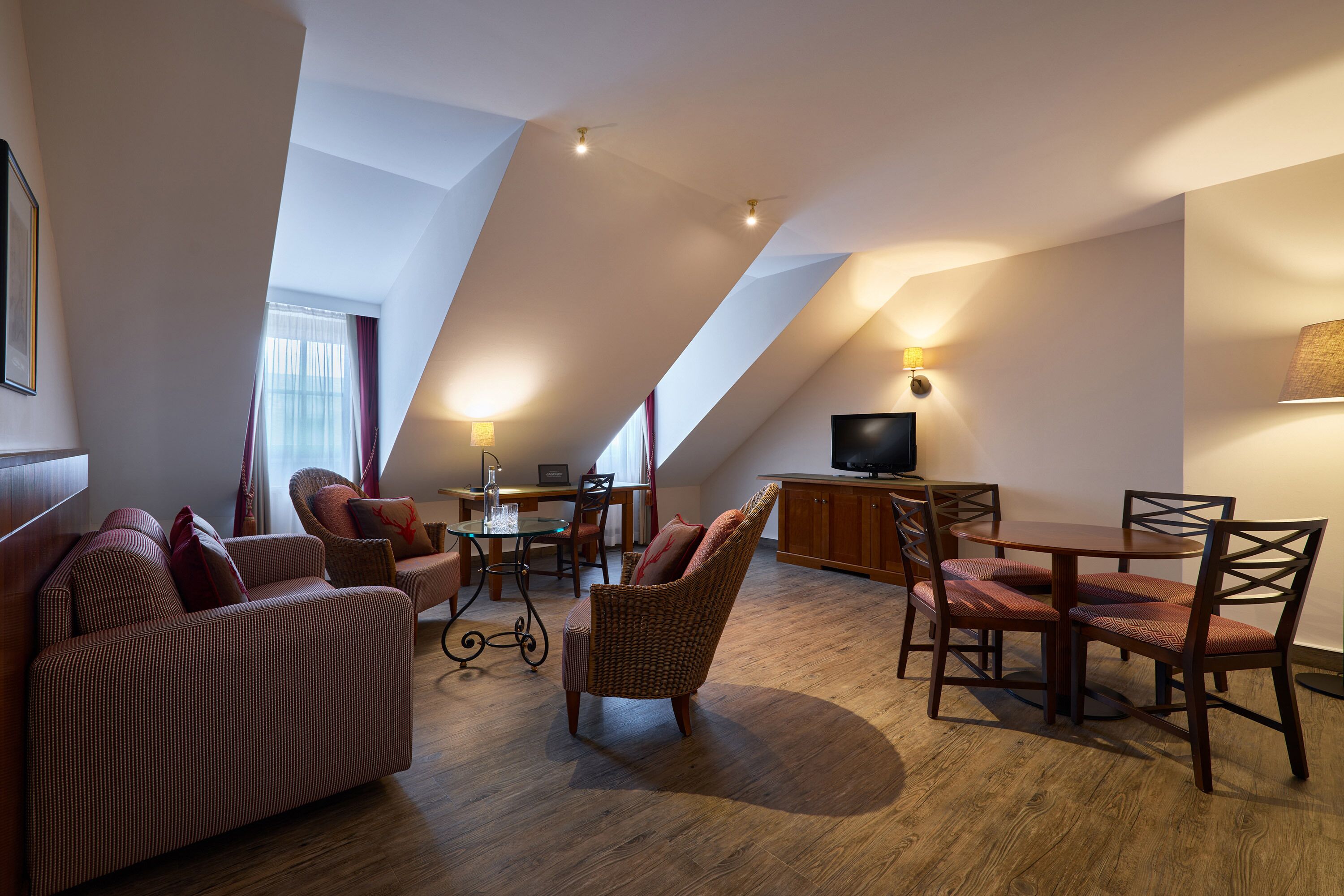 A modern loft-style living area with a high ceiling, a dining table, and comfortable seating.