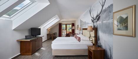 A modern hotel room with a large bed, skylight, wooden furniture, and a scenic wall mural.