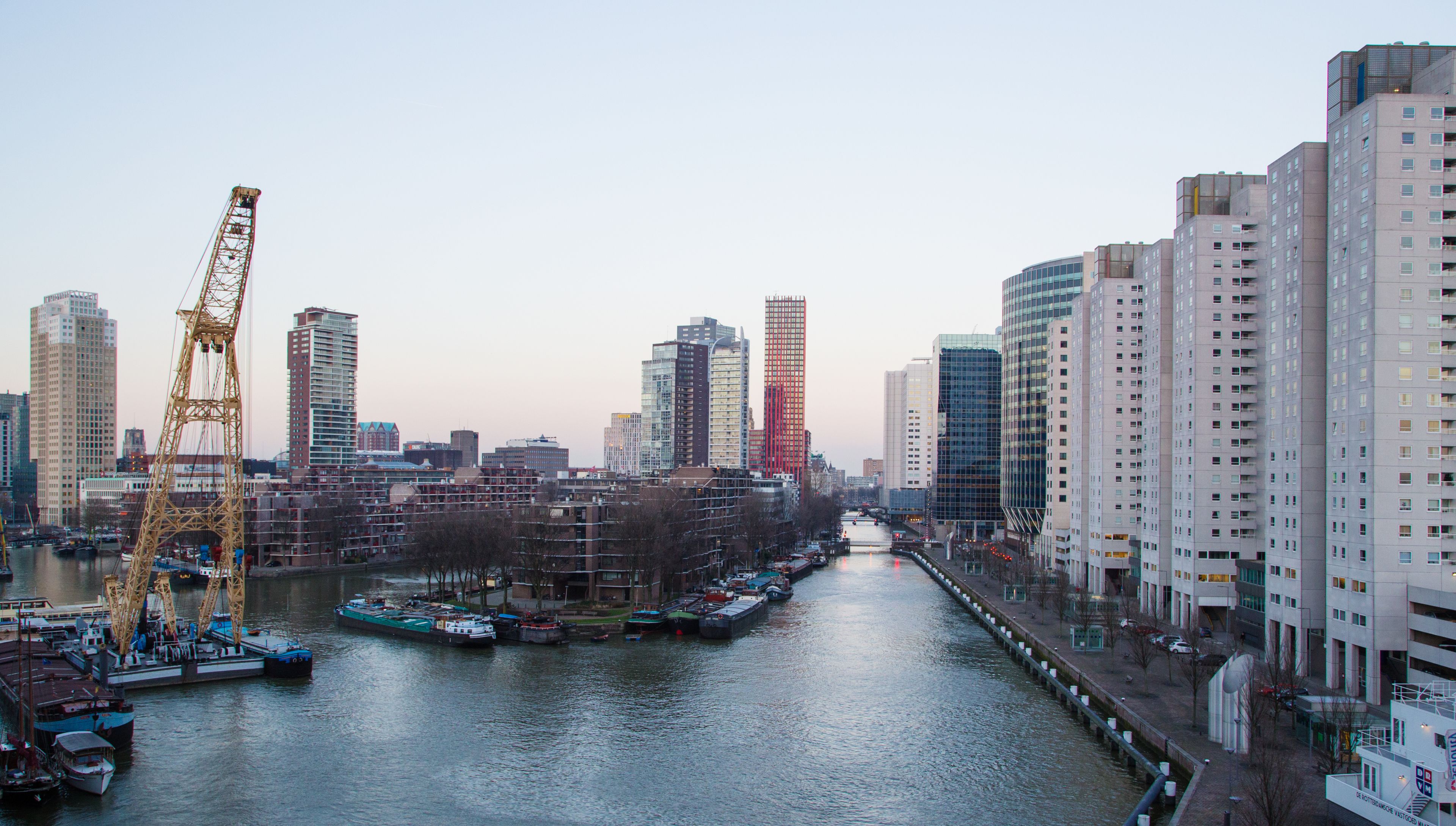 A cityscape with a river, high-rise buildings, and a crane.