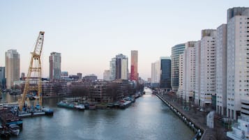 A cityscape with a river, high-rise buildings, and a crane.