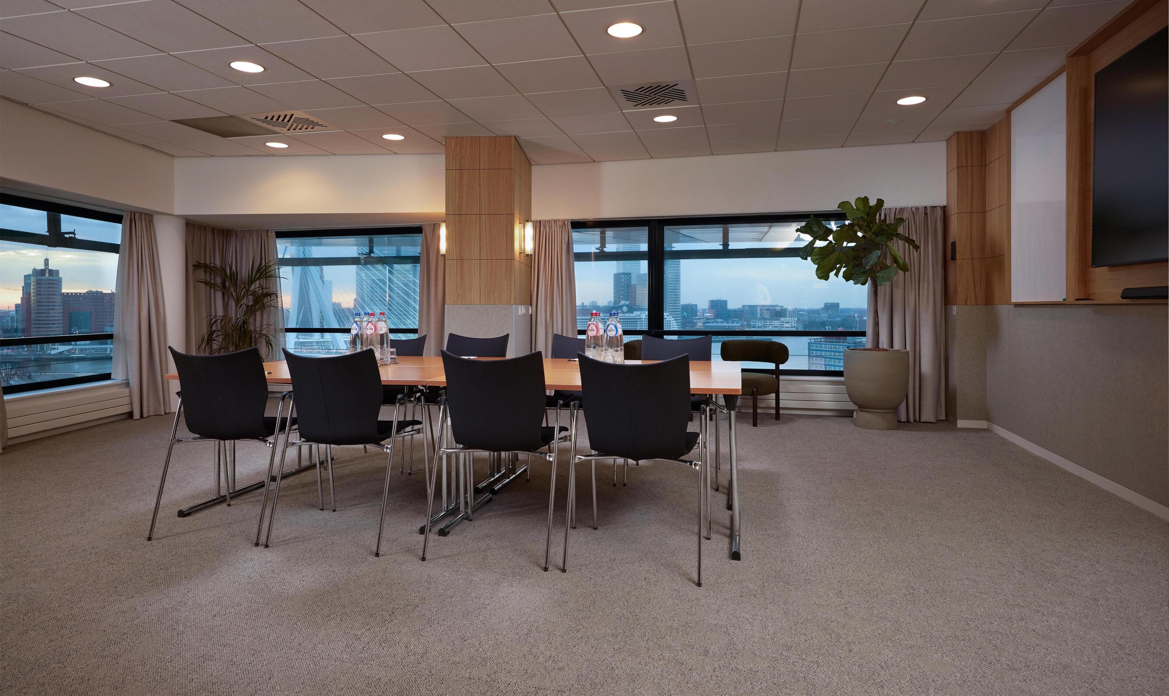 A conference room with a city view, a large table, and four chairs.