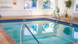 An indoor swimming pool with clear water, a diving board, and a window with a view of the outside. - Quality Inn & Suites Longview Kelso (Longview)