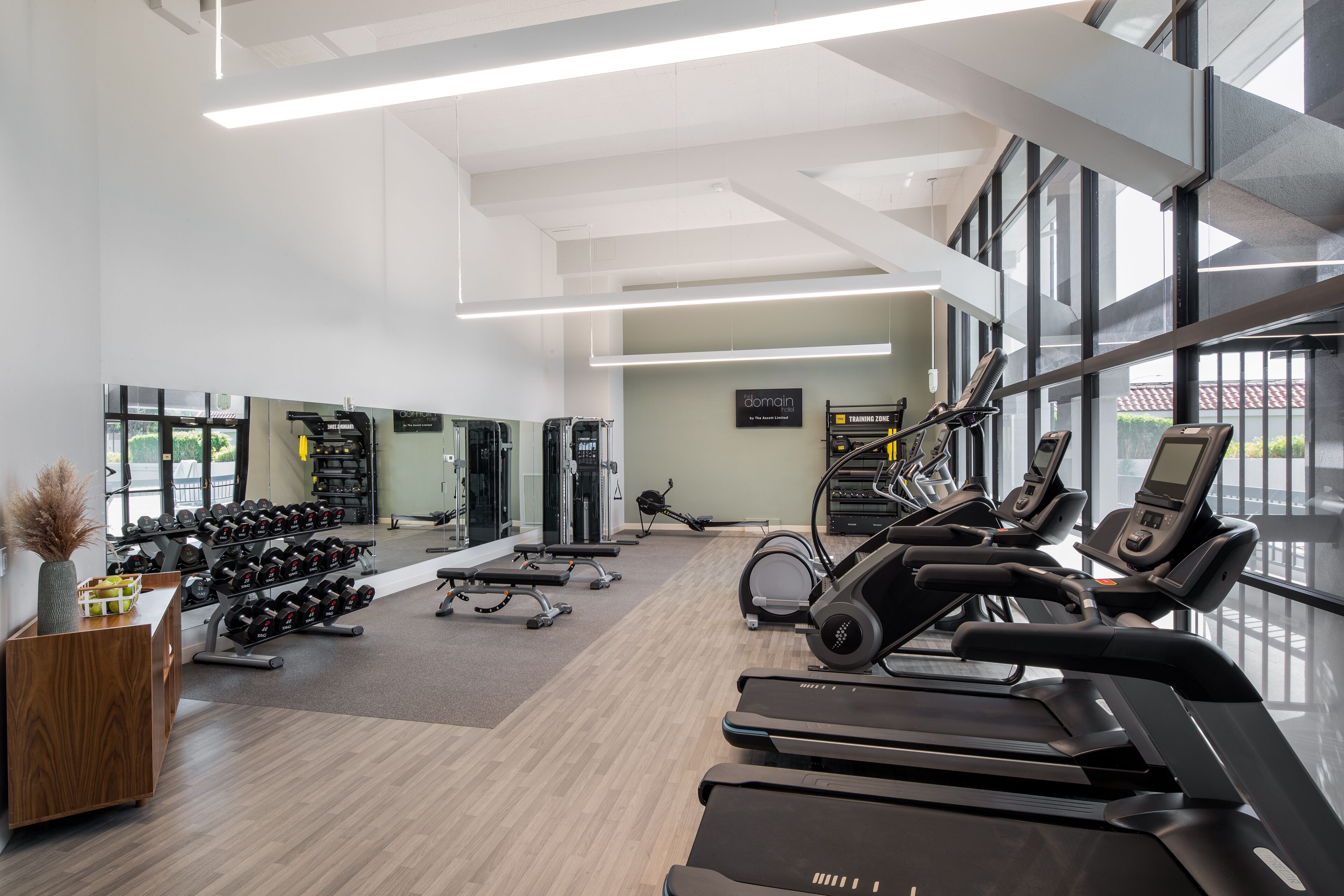 A spacious gym with treadmills, dumbbells, and exercise equipment.