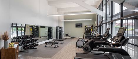 A spacious gym with treadmills, dumbbells, and exercise equipment.