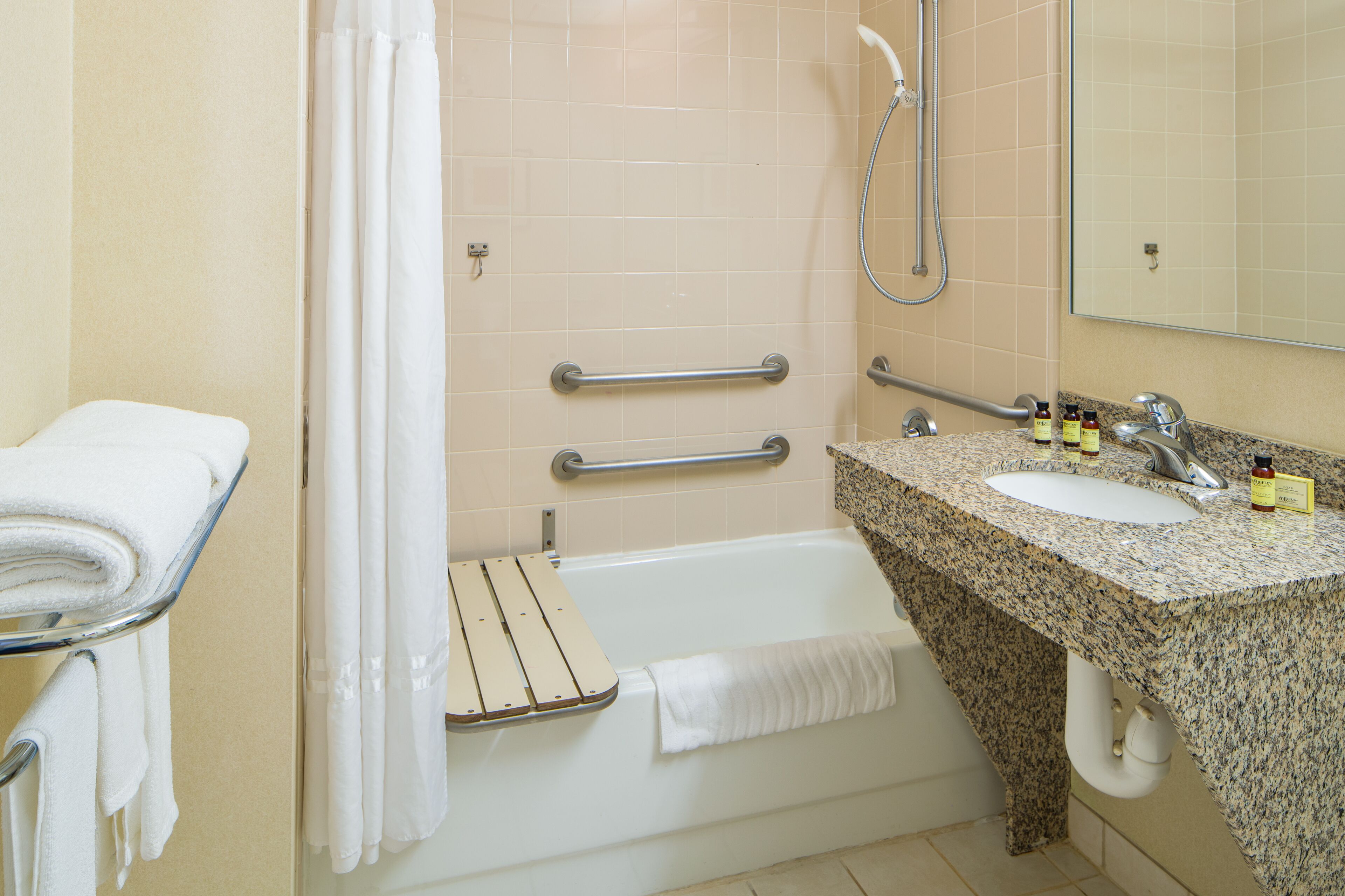 A bathroom with a bathtub, a shower, a sink, and a mirror.