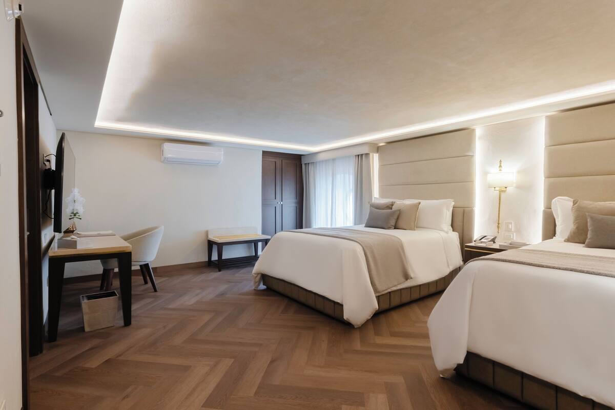 Une chambre d’hôtel moderne avec un grand lit, un bureau et une chaise.