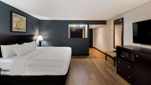 A hotel room with a bed, a TV, a dresser, a lamp, and a painting on the wall. - Clarion Hotel San Angelo near Convention Center (San Angelo)