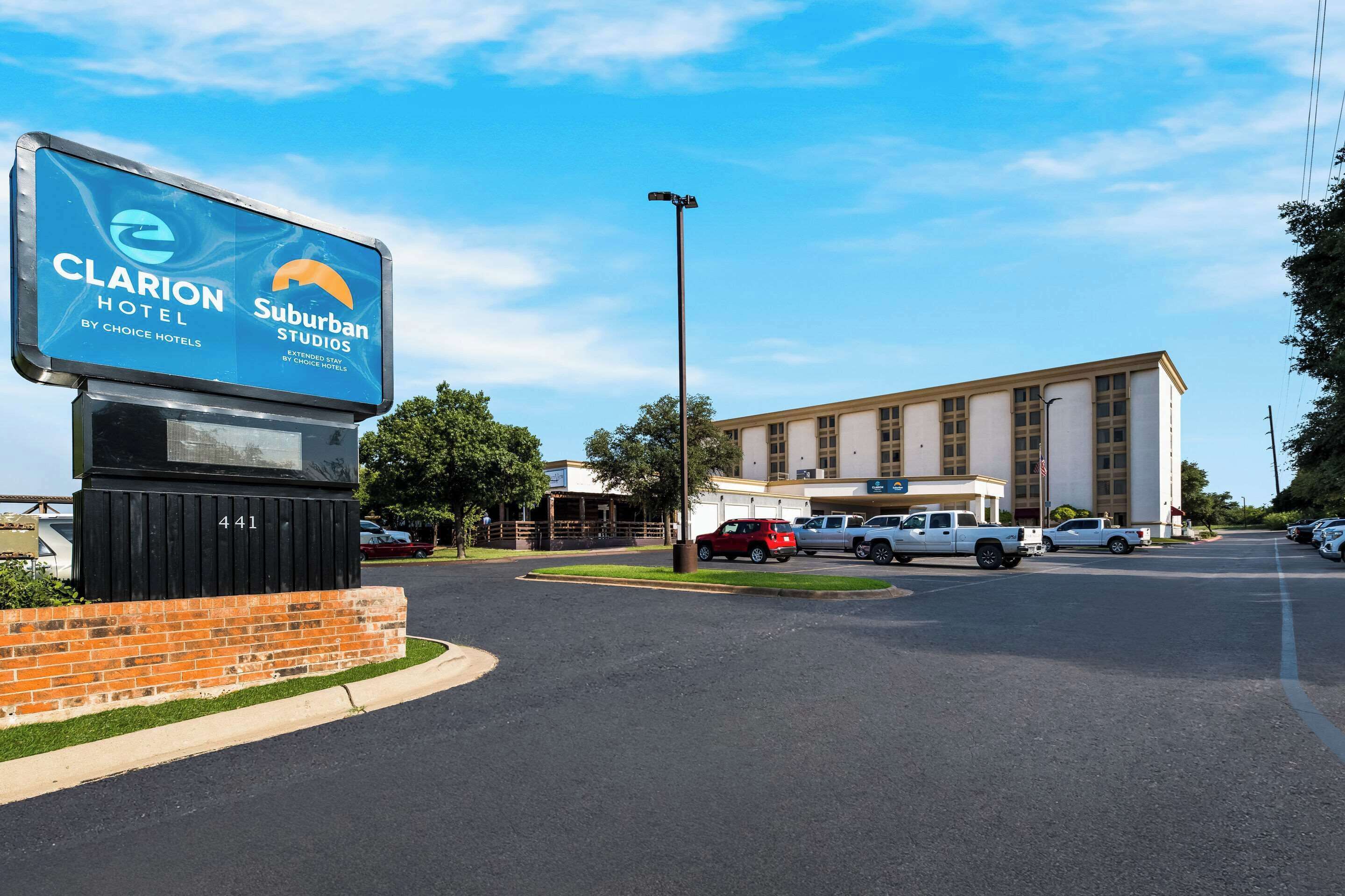 A hotel sign for Clarion Hotel by Choice Hotels and Suburban Studios.