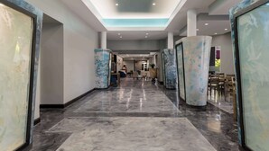 A hotel corridor with marble flooring, large columns, and a modern ceiling design. - Clarion Hotel San Angelo near Convention Center (San Angelo)