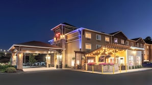 A hotel with a covered entrance, outdoor seating area, and a sign indicating 'Welcome'. - Hampton Inn Pullman (Pullman)