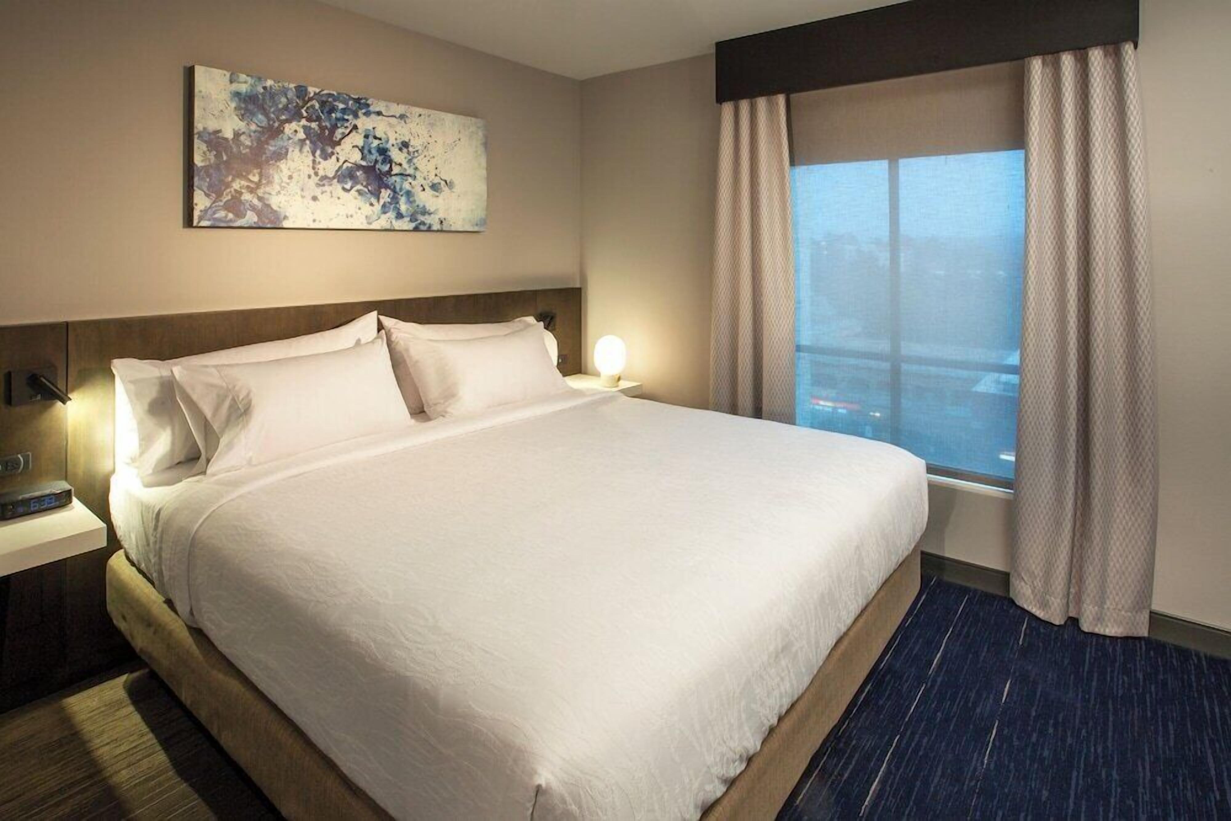 Hypo-allergenic bedding, desk, laptop workspace, blackout drapes