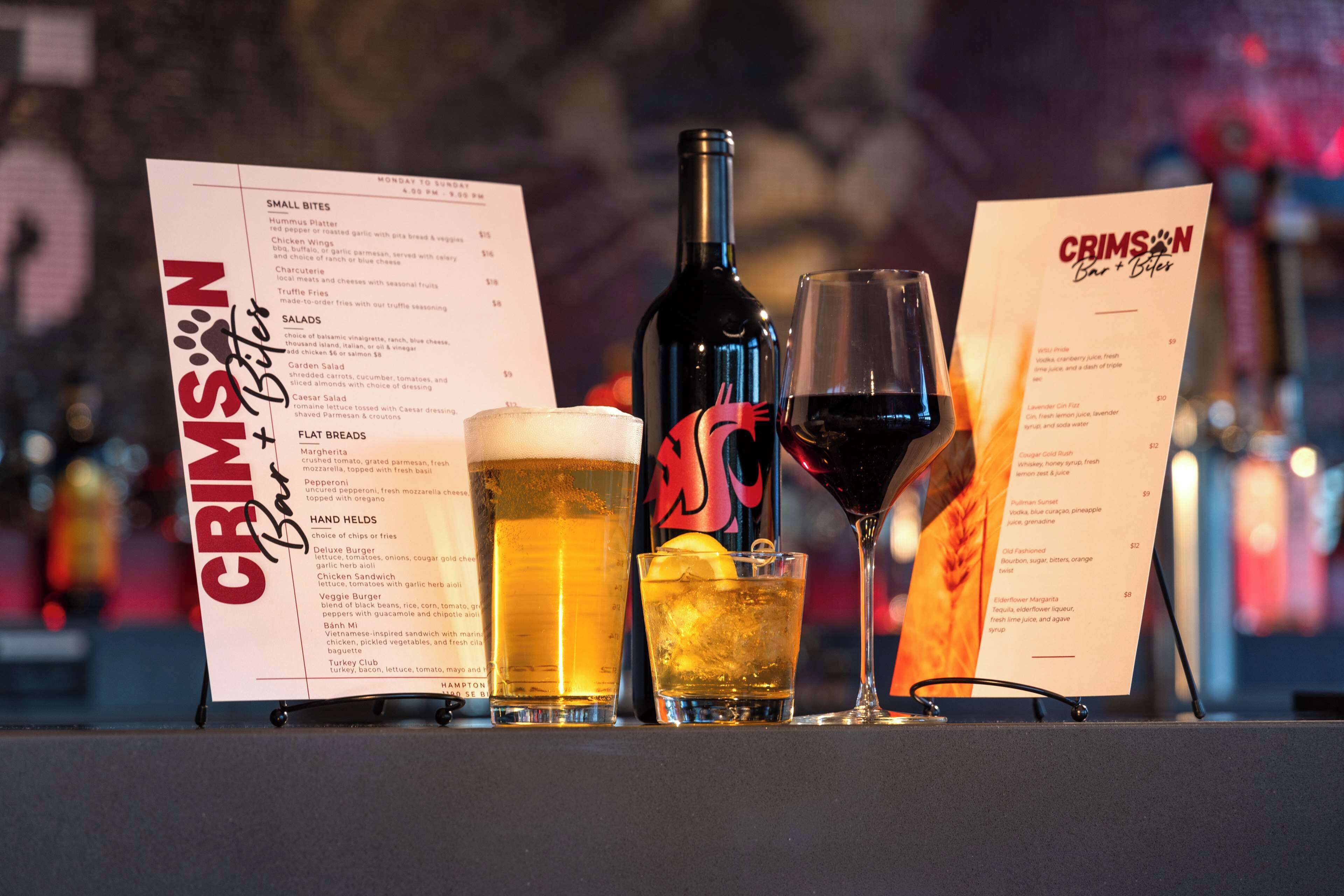 A menu board with a drink and a bottle of wine.