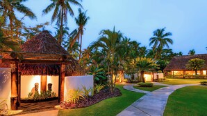 A resort with a thatched-roof structure, palm trees, and a well-maintained lawn. - The Westin Fiji Golf Resort & Spa (Nadi)