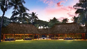 A thatched-roof structure with tables and chairs, surrounded by palm trees, likely a dining or event space. - The Westin Fiji Golf Resort & Spa (Nadi)