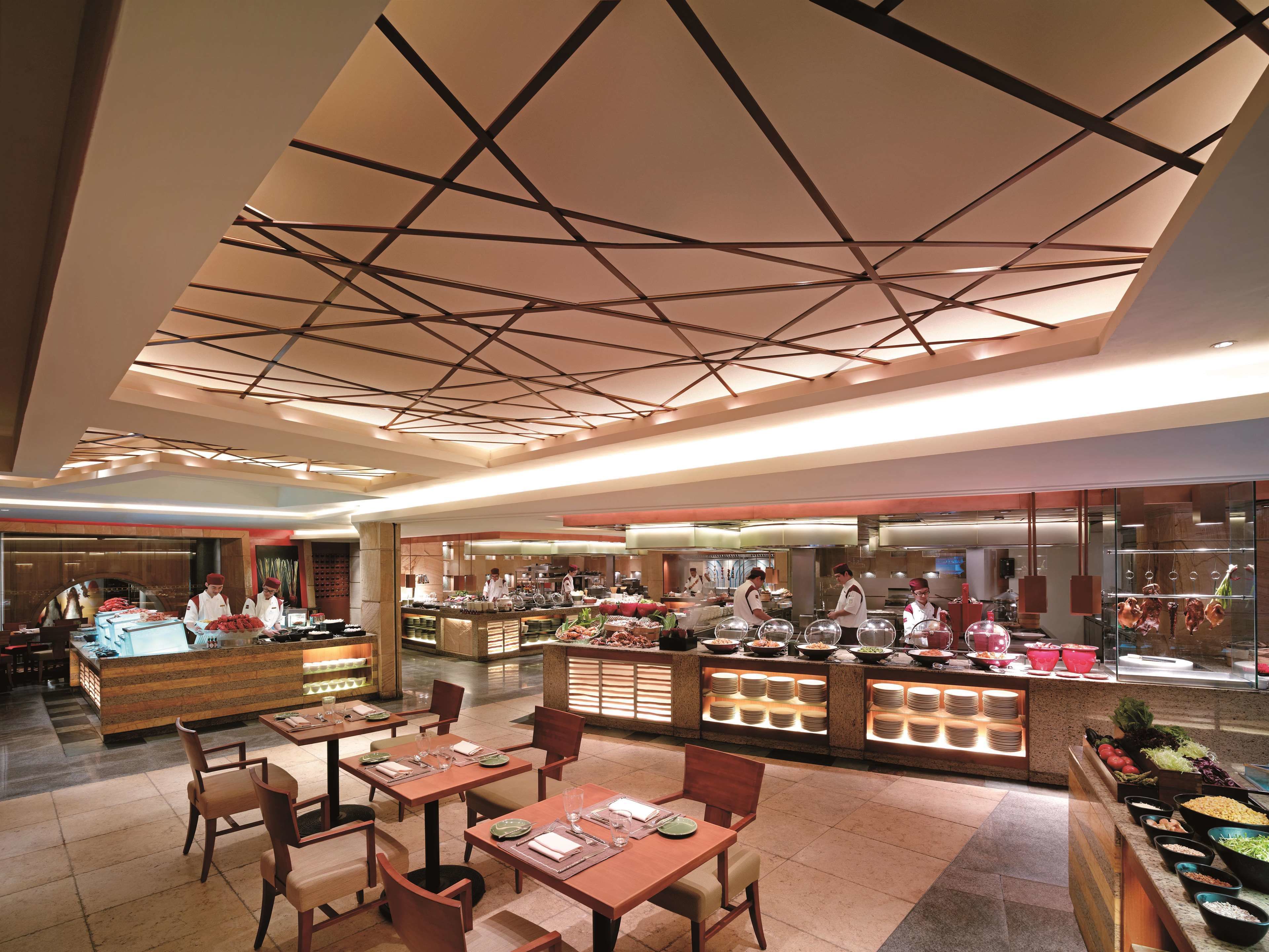A buffet-style restaurant with multiple serving stations, a central counter, and seating areas.