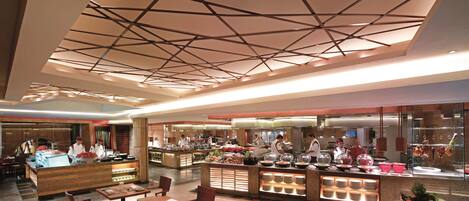 A buffet-style restaurant with multiple serving stations, a central counter, and seating areas.
