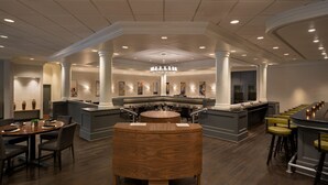 Een ruime hotellobby met een centraal gelegen eiland, zitgedeeltes en een bar.