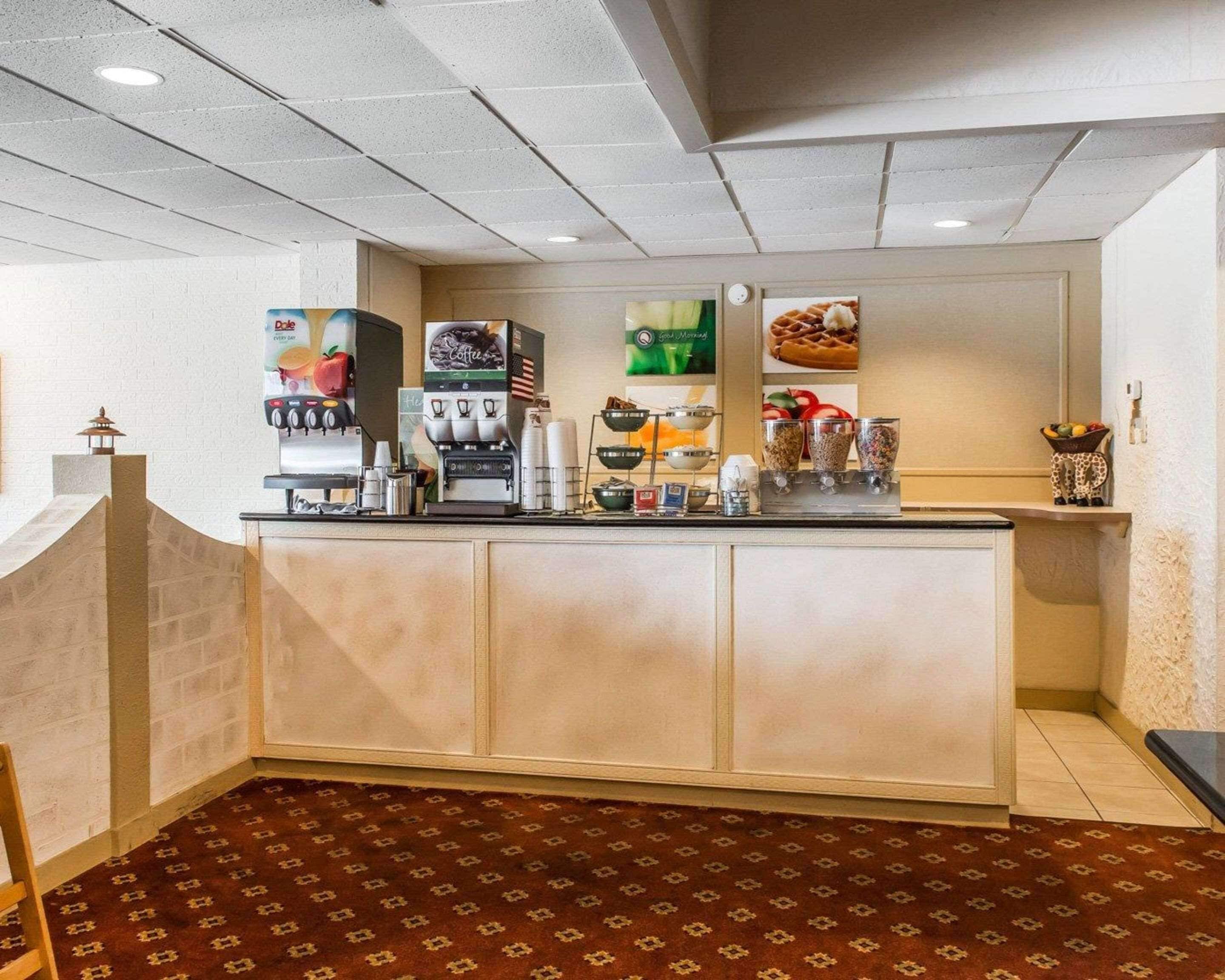 Un coin café équipé d’une machine à café, d’un présentoir à gaufres et d’un saladier rempli de fruits.